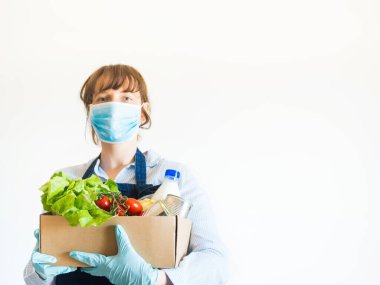 Maskeli, yemek kutulu, mavi elbiseli kadın.