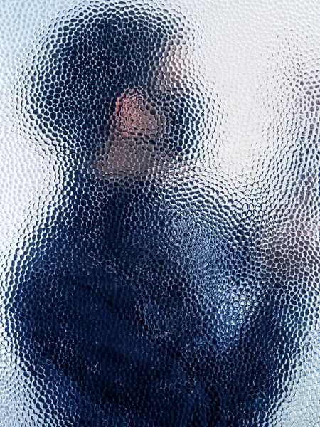 Muž v černé masce za zavřenými dveřmi sklo — Stock fotografie