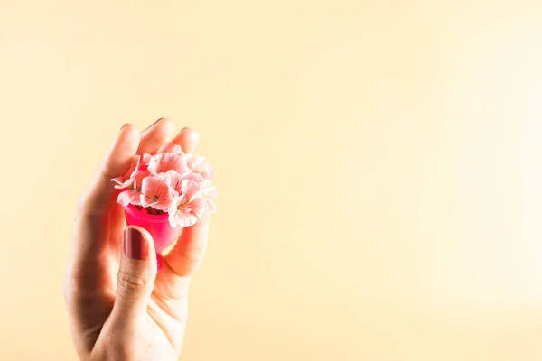 Růžový menstruační pohár v dlani ženské ruky — Stock fotografie