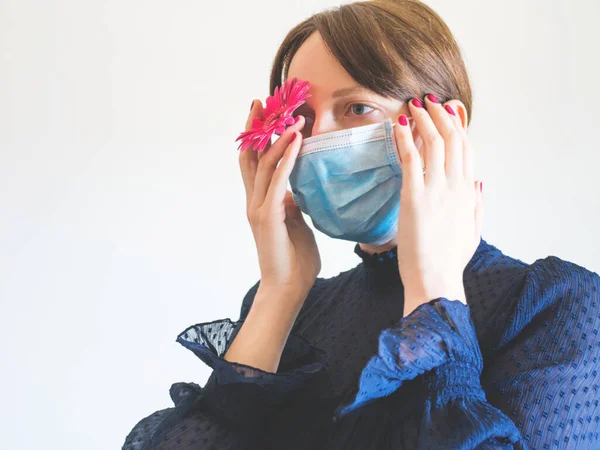 Schönes Frauenporträt in Gesichtsmaske mit rosa Blume — Stockfoto