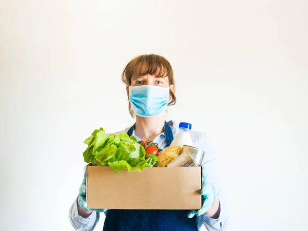 Frau in blauer Gesichtsmaske mit Essenslieferbox — Stockfoto
