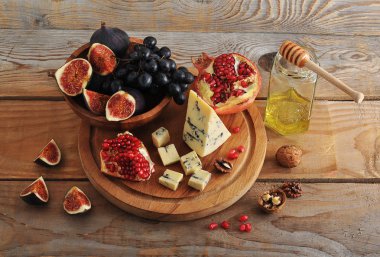 incir ve ahşap bir kabın içinde siyah üzüm