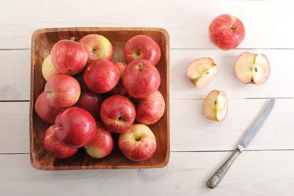 Rode rijpe appels in een plaat op houten achtergrond — Stockfoto