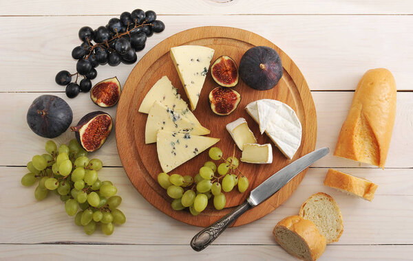 cheese plate - various types of cheeses and figs and grapes on a