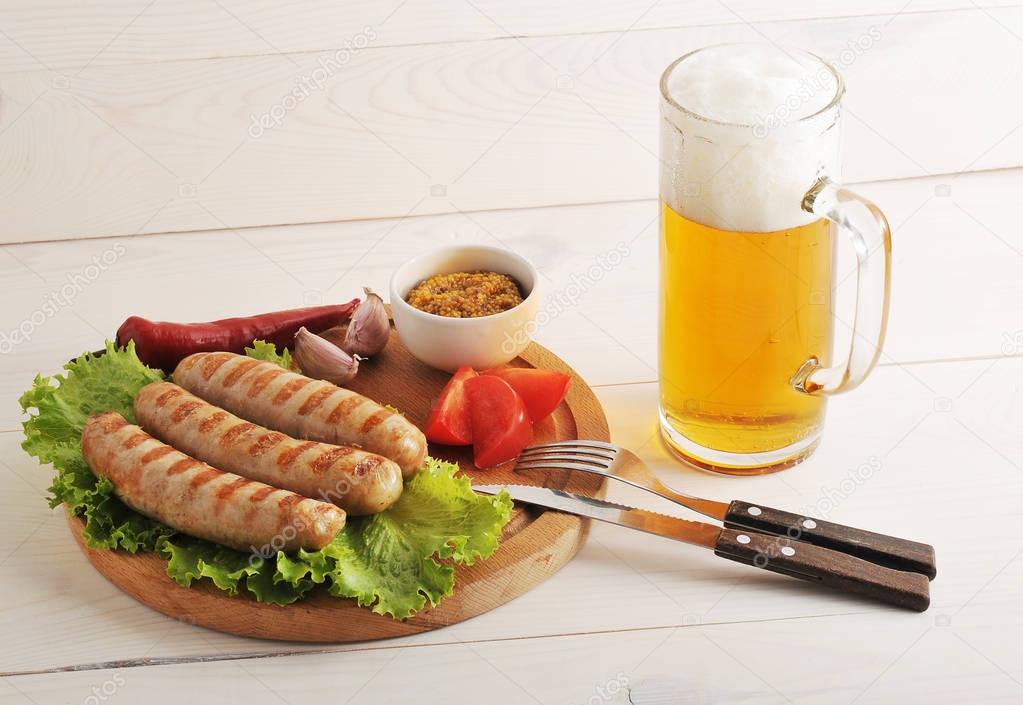 Bavarian sausages grilled on a wooden round Board and beer