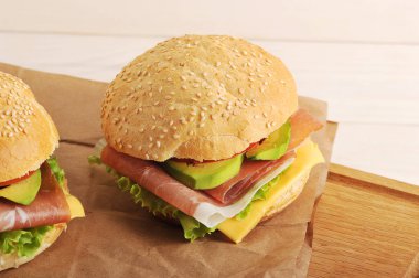 Burger pastırma ve Kraft kağıt üzerinde avokado 