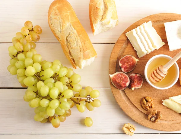 Pequeno-almoço continental - queijo, mel, figos, nozes, uvas e — Fotografia de Stock