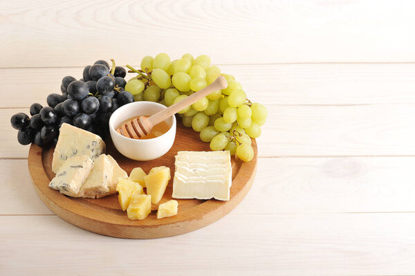 cheese plate - various types of cheese, grapes green and black, 