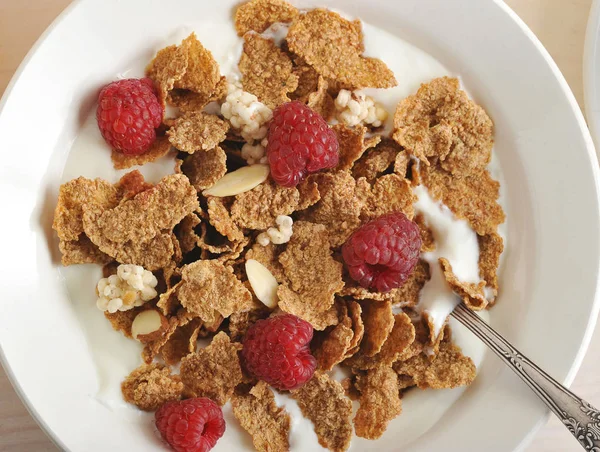 Cereal with raspberries and almonds and rice flakes and milk in — Stock Photo, Image