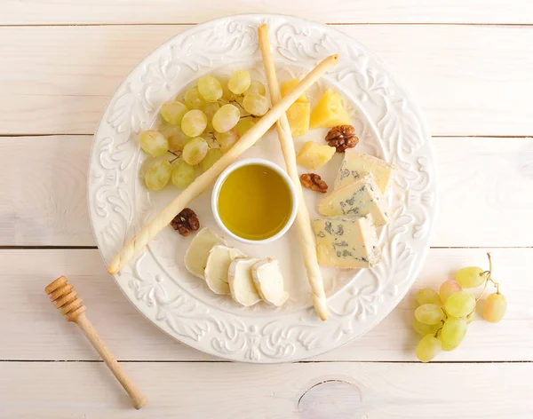 Prato de queijo com uvas, mel e nozes — Fotografia de Stock