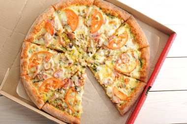 Pizza dilimleri mantar, domates, peynir ve domuz pastırması ile kesmek