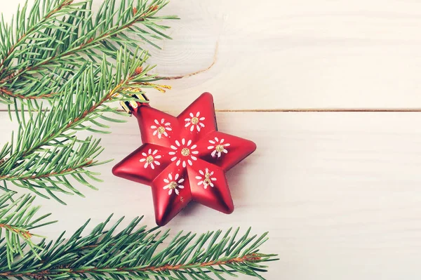 Brinquedo de árvore de Natal vermelho na forma de estrelas em um ramo de abeto — Fotografia de Stock