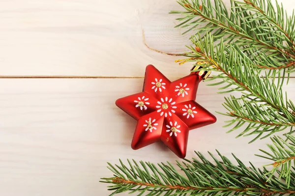 Rotes Weihnachtsbaumspielzeug in Form von Sternen auf einem Tannenzweig — Stockfoto