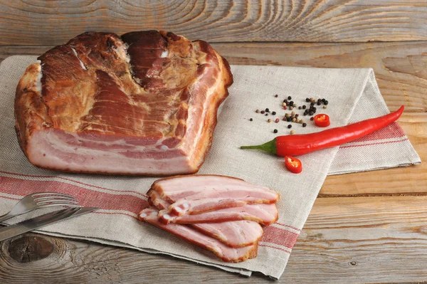 El pedazo de la carne de cerdo ahumada - el lomo a la servilleta de lino — Foto de Stock