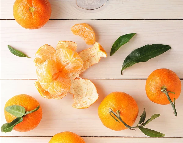 Tangerinas com folhas verdes sobre fundo de madeira — Fotografia de Stock