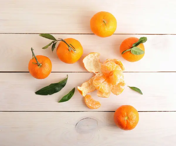 Tangerinas com folhas verdes sobre fundo de madeira — Fotografia de Stock