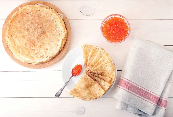 Red caviar in the spoon and pancakes in plate — Stock Photo, Image