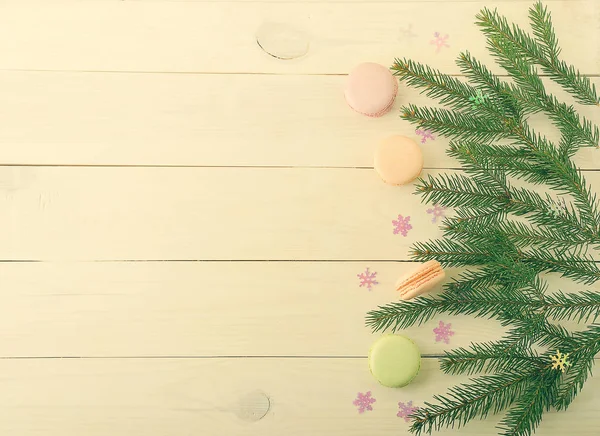 Pastel macarons con ramas de árbol de Navidad y copos de nieve en woo —  Fotos de Stock