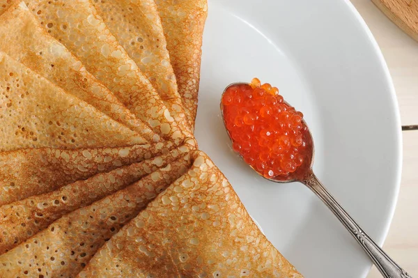 Caviar rojo en la cuchara y panqueques en el plato —  Fotos de Stock