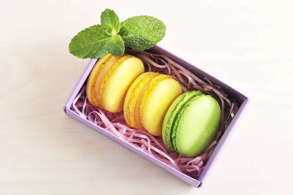 Macarons de bolo amarelo e verde com hortelã na caixa no backgr de madeira — Fotografia de Stock