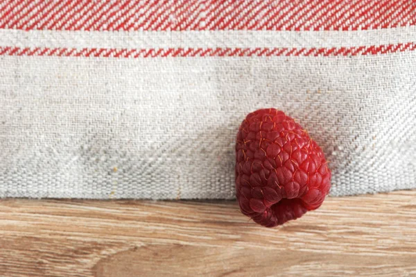 En röda hallon på en bakgrund av linne servetter — Stockfoto