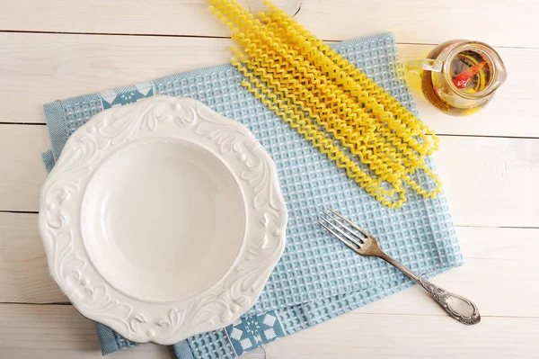 Empty plate and ingredients for cooking pasta — Stock Photo, Image