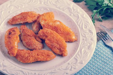 ahşap zemin üzerinde bir kapta tavuk kanadı