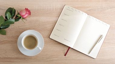 kırmızı gül ve bir fincan kahve ve günlüğü olan maddeler ile