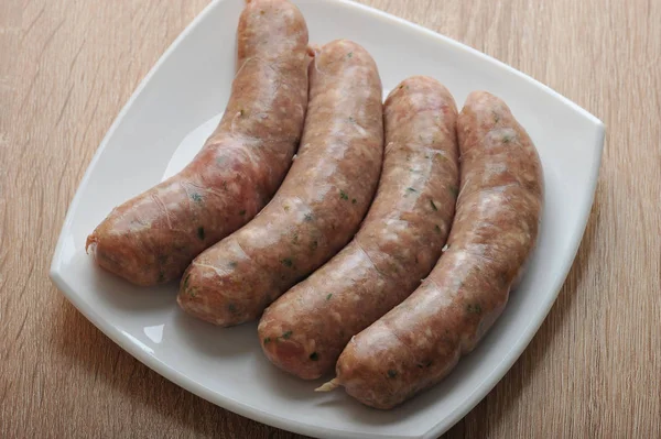 Raw meat sausages kupaty in white plate — Stock Photo, Image