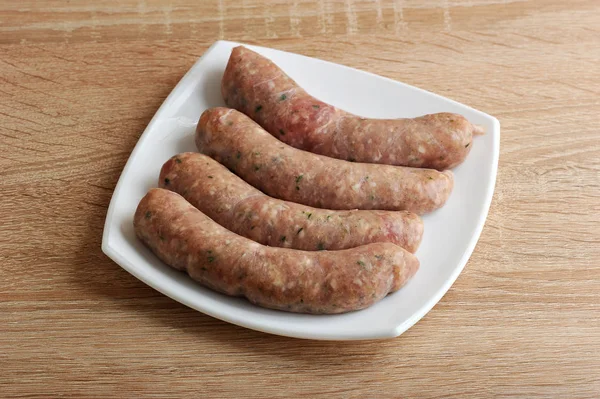 Salsichas de carne crua kupaty em placa branca — Fotografia de Stock