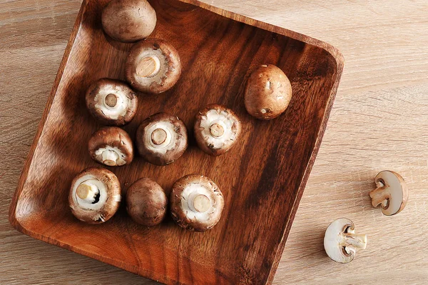Färsk rå brun kastanj svamp hela i kvadratisk träplatta — Stockfoto