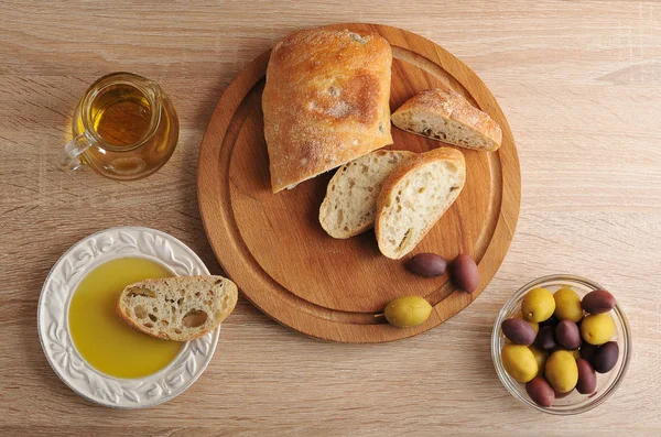 Нарезанный хлеб чиабатта, оливки и оливковое масло — стоковое фото