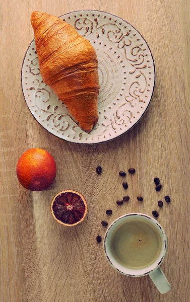 羊角面包在盘子里一杯咖啡和红血橙 — 图库照片