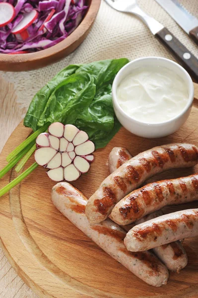 Grillwürste mit Sauce, Spinat und Knoblauch — Stockfoto