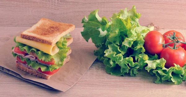 Multilayered sandwich with cheese, ham, tomatoes and lettuce — Stock Photo, Image