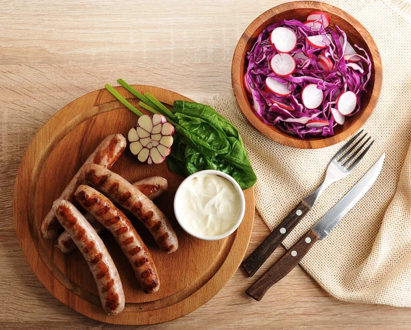 Bratwürste vom Grill mit Sahnesoße und einem Radi-Salat — Stockfoto