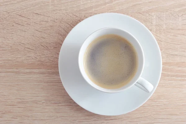 Чашка кофе в белом с блюдцем на деревянном фоне — стоковое фото