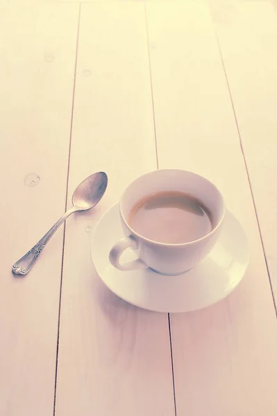 Weiße Kaffeetasse und Untertasse mit einem Teelöffel — Stockfoto