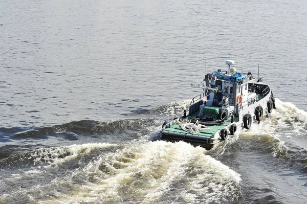 Rebocador de navio com um traço na água do motor rabotayushih — Fotografia de Stock