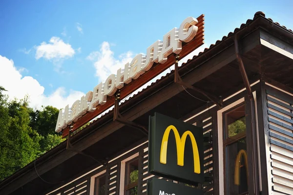 Schild und das Logo von mcdonald 's im Hintergrund des Bergwaldes — Stockfoto