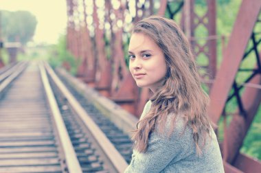 Hırka raylar üzerinde oturan genç güzel kadın