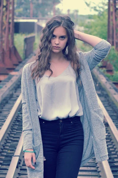 Dívka teenager s tekoucí hnědé vlasy v pozadí railw — Stock fotografie