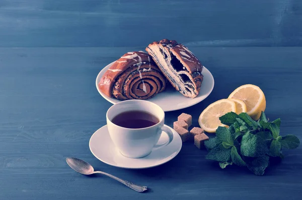 Рулон с маком семян, чай, лимон и мята на деревянном фоне — стоковое фото