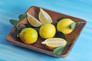 mavi renkli bir tabağa yapraklarda ile taze sarı limon