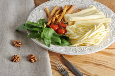 Fesleğen ve kiraz domates ile bir kasede peynir türleri