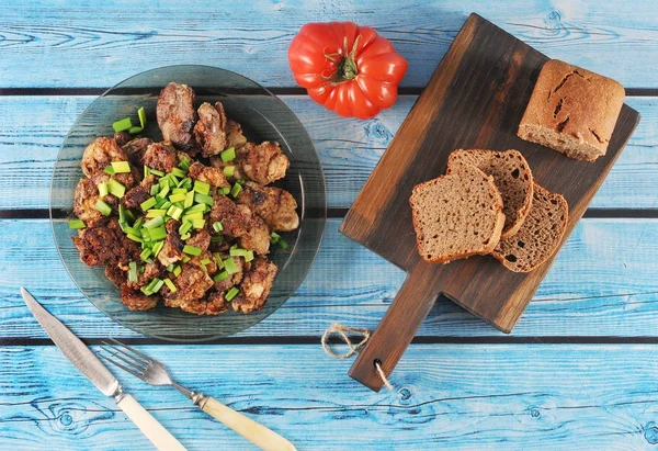Смажена печінка з цибулею на тарілці, помідорами та житнім хлібом — стокове фото