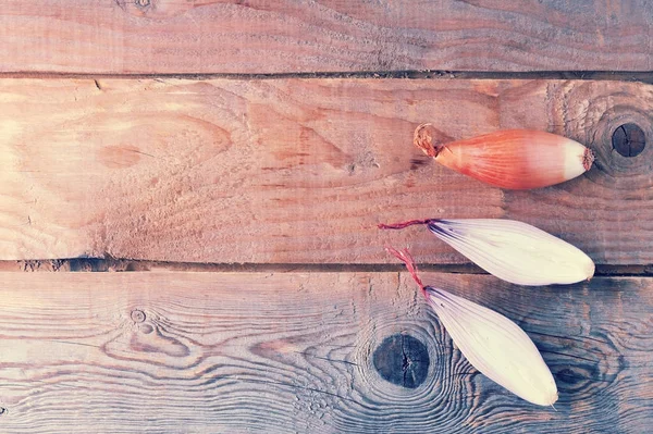 Cebolla entera y media en rojo sobre fondo de madera rugosa —  Fotos de Stock