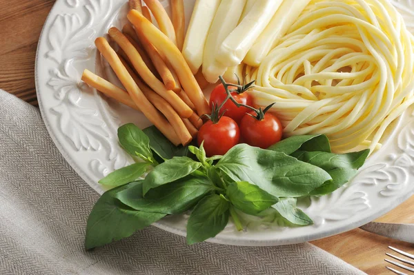 Fesleğen ve kiraz domates ile bir kasede peynir türleri