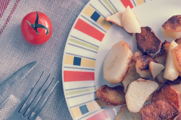 Batatas fritas douradas no prato e tomates Chery — Fotografia de Stock