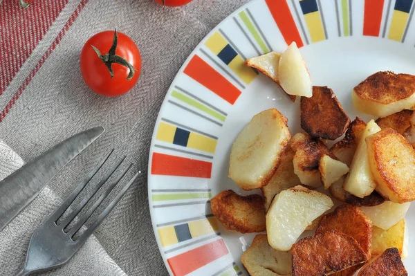 Goldene Chips auf dem Teller und Tomaten — Stockfoto